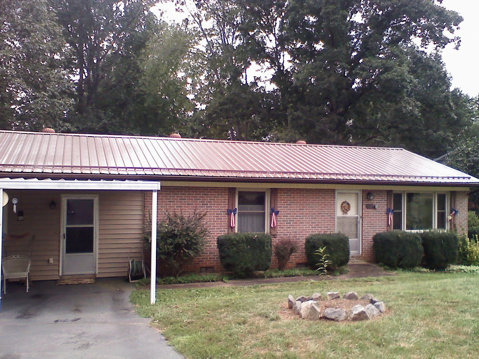 Bronze metal roof and carport on a brick ranch home — Roof Repair work by our crew in Birds Landing